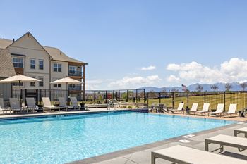 a swimming pool with chairs and a building in the background at Upland Flats, Colorado, 80922